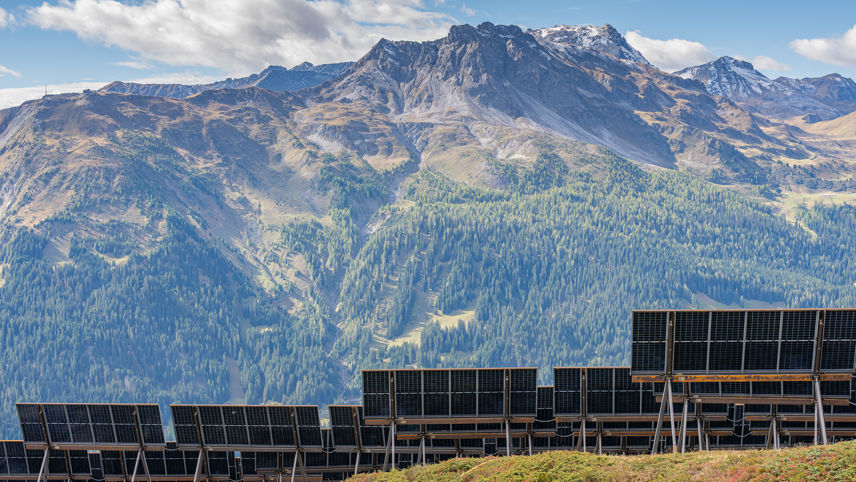 Madrisa Solar: Solarpanels auf alpiner Fläche mit Bergkulisse im Hintergrund.