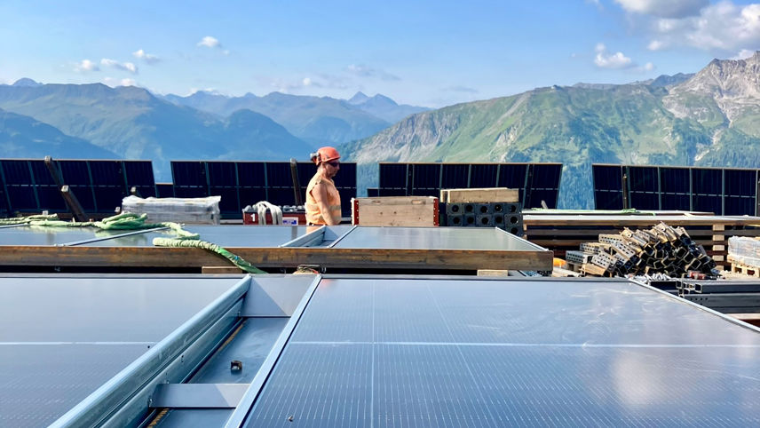 Montage von Solarpanels auf der Madrisa; im Hintergrund Bergpanorama.