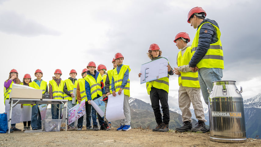 Kinder befüllen beim Spatenstich die Zeitkapsel von Madrisa Solar mit Zeichnungen und Botschaften für die Zukunft.