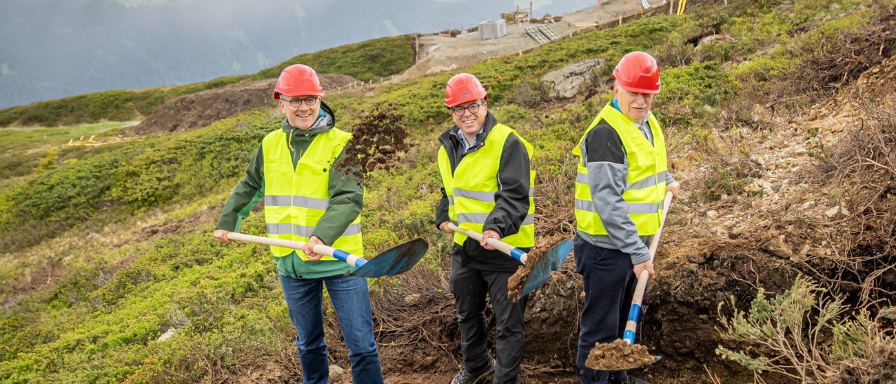 Drei Männer mit Schaufeln beim Spatenstich für das alpine Solarkraftwerk Madrisa Solar.